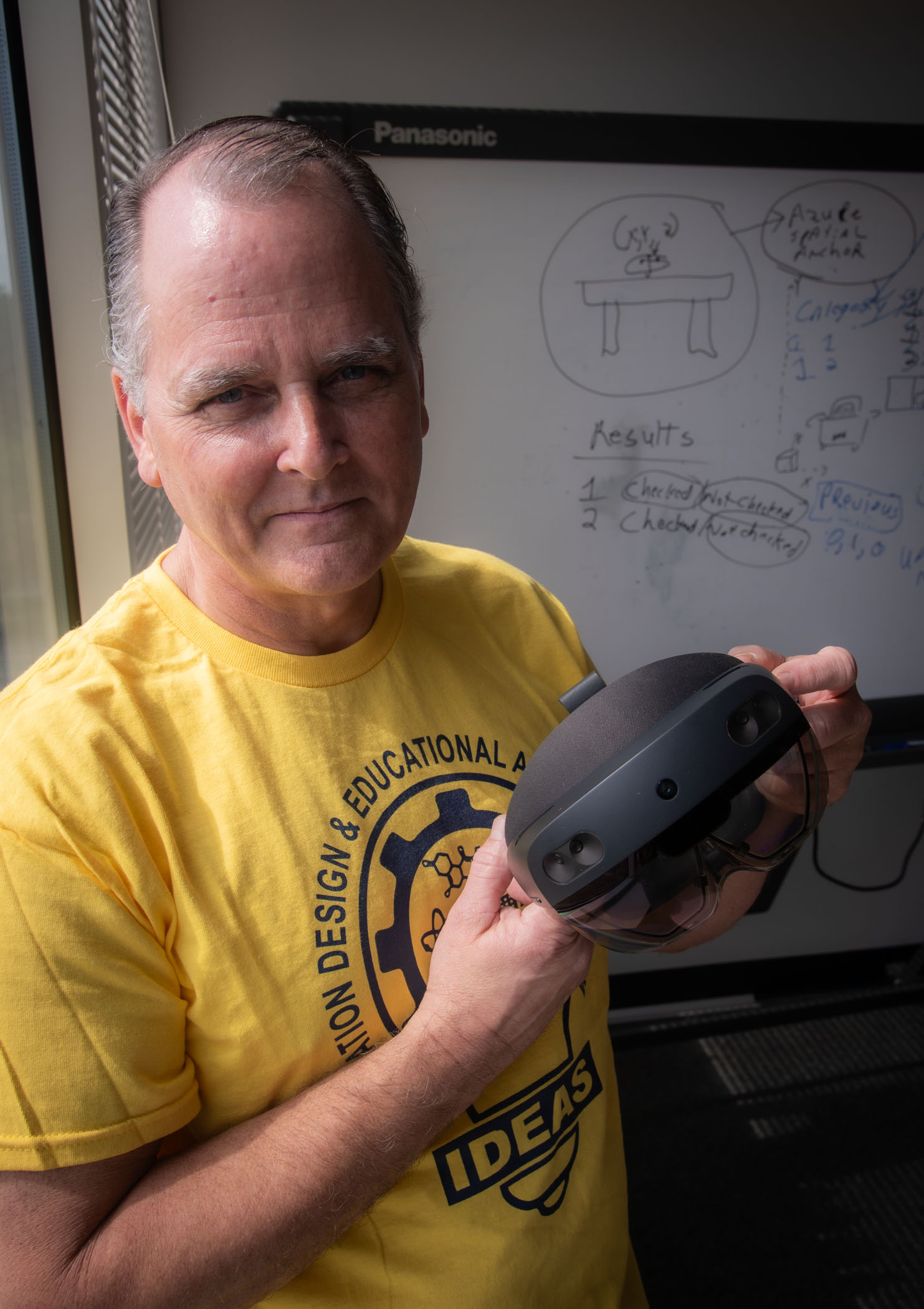 Photo of Donald Zuvich holding VR goggles